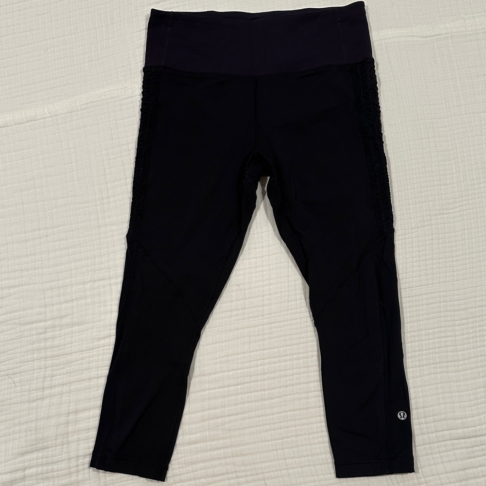 Black lululemon cropped leggings with violet waistband and ruffle accent
